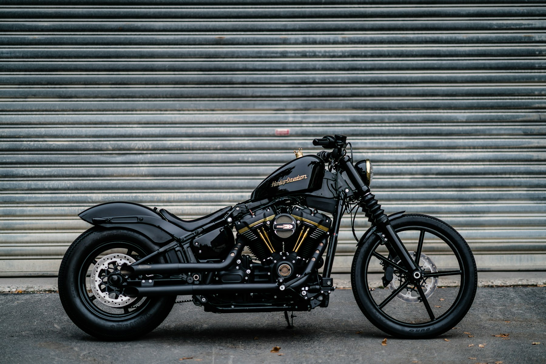 Stand-in Unsplash photo of a black Harley-Davidson parked in front of a roller shutter